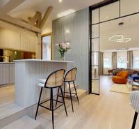 Innenraum einer 4-Zimmer-Wohnung mit Glaswand, Bartresen und Boden mit Holzdekor.