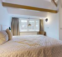 Schlafzimmer in einer 4-Zimmer-Wohnung mit großem Bett und Dachfenster.