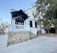 Das Gebäude in der Vajanského-Straße in Prešov mit einer Steinterrasse und Bäumen.