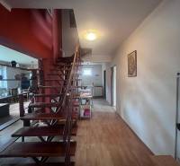 Innenraum eines Einfamilienhauses mit Holztreppe und Boden in Holzoptik.