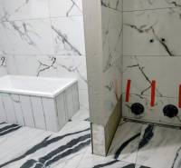 Ein Badezimmer in einem Einfamilienhaus mit Marmorverkleidung und Badewanne, raffiniertes Design.