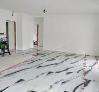 Innenraum eines Einfamilienhauses mit Marmorboden und weißen Wänden.