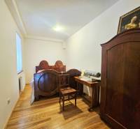 Schlafzimmer mit antiken Möbeln, Bett und Schrank mit Holzboden.