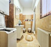 3-Zimmer-Wohnung mit Badezimmer, Waschmaschine, Badewanne und Fenster, dekorative Wandverkleidungen.