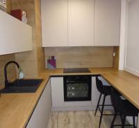 Eine Küche mit Holzboden in einer 2-Zimmer-Wohnung, ausgestattet mit bequemen Sitzgelegenheiten.