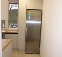 Küche mit Holzboden und Kühlschrank in einer 2-Zimmer-Wohnung.