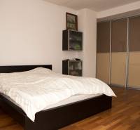 Schlafzimmer in einem Einfamilienhaus mit Bett und Schrank, Boden mit Holzdekor.