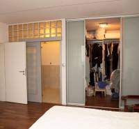 Schlafzimmer im Einfamilienhaus mit Schiebetüren und Kleiderschrank, Boden mit Holzdekor.