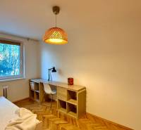 Ein Zimmer in einer 3-Zimmer-Wohnung mit einem Boden in Holzoptik, einem Schreibtisch und einer Lampe.