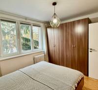 Schlafzimmer in einer 3-Zimmer-Wohnung mit einem großen Schrank und einem Fenster mit Blick auf Bäume.