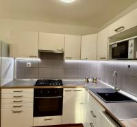 Küche in einer 3-Zimmer-Wohnung mit weißen Schränken und eingebautem Gerät.