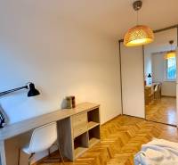Arbeitsbereich mit einem Holztisch und einem Boden mit Holzdekor in einer 3-Zimmer-Wohnung.