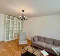 Wohnzimmer in einer 3-Zimmer-Wohnung mit Holzboden, hellen Möbeln und Sofa.