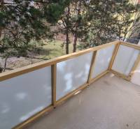 Balkon einer 2-Zimmer-Wohnung mit Blick ins Grüne, mit durchsichtigem Geländer.