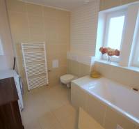 Badezimmer mit Badewanne, Fliesen und Waschmaschine in einer 2-Zimmer-Wohnung.