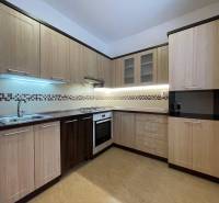 Küche in einer 2-Zimmer-Wohnung mit Holzboden und hellen Möbeln.