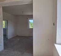 Innenraum eines Einfamilienhauses mit unfertigen Wänden und Betonboden.