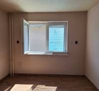 Ein Zimmer in einem Einfamilienhaus mit offenem Fenster und einem Boden in Holzoptik.