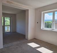 Izba v einem Einfamilienhaus, große Fenster, Blick auf den Garten und die umliegenden Bäume.