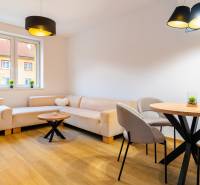 Wohnzimmer mit Sofas, rundem Tisch und Holzboden in einer 3-Zimmer-Wohnung.