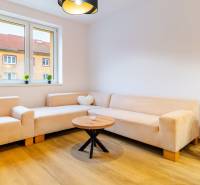 Helles Wohnzimmer in einer 3-Zimmer-Wohnung mit beigem Sofa und Holzboden.