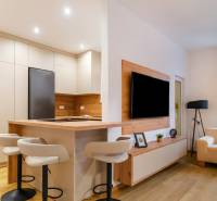 Küche und Wohnzimmer in einer 3-Zimmer-Wohnung mit Holzboden, gemütliche Sitzecke.