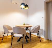 Elegantes Esszimmer in einer 3-Zimmer-Wohnung mit rundem Tisch und Stühlen, Boden mit Holzdekor.