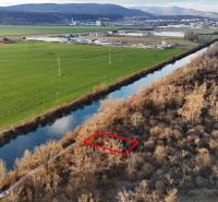 Freizeitgrundstücke am Fluss in Nová Ves nad Váhom, umgeben von Natur und Feldern.