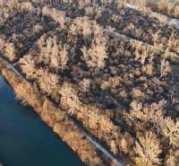 Ein von Bäumen umgebener Fluss auf Erholungsgrundstücken in der Stadt Nová Ves nad Váhom.