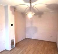 Ein Zimmer in einem Einfamilienhaus mit einem Boden in Holzoptik und einer hängenden Leuchte.