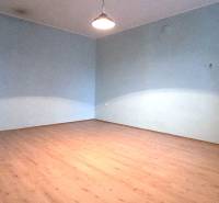 Ein Zimmer in einem Einfamilienhaus mit einem Boden in Holzoptik und blauen Wänden.