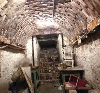 Ein traditioneller Keller in einem Einfamilienhaus, voll mit Eingemachtem und antiken Möbeln.