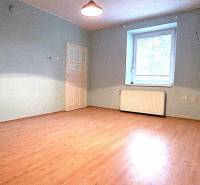 Ein Zimmer in einem Einfamilienhaus mit einem Boden in Holzoptik und blauen Wänden.