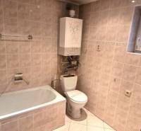 Badezimmer in einem Einfamilienhaus mit Badewanne, Toilette und Wandheizung.