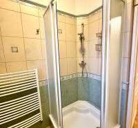 Badezimmer mit Duschkabine und Fliesen in einer 4-Zimmer-Wohnung.