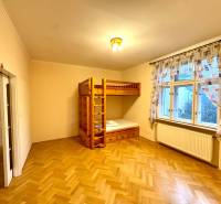 Schlafzimmer in einer 4-Zimmer-Wohnung mit einem Etagenbett und einem Boden mit Holzdekor.