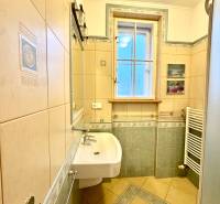 Badezimmer mit Fliesen, Duschkabine und Waschbecken in einer 4-Zimmer-Wohnung.