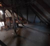 Der Dachboden eines Einfamilienhauses mit Holzbalken und gelagerten Kisten.