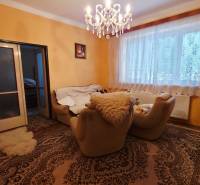 Wohnzimmer in einem Einfamilienhaus mit Teppichen, Kronleuchter und bequemen Sesseln.