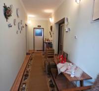 Der Flur im Einfamilienhaus mit dekorativen Tellern an der Wand und einem Teppich.