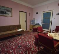 Wohnzimmer in einem Einfamilienhaus mit rotem Teppich und Holzmöbeln.