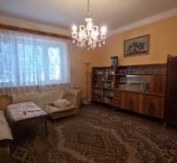 Wohnzimmer in einem Einfamilienhaus mit Kronleuchter und Möbeln, Boden mit dekorativem Teppich.