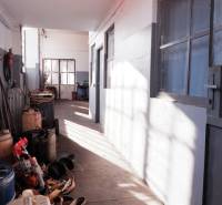 Ein enger Flur in Produktionsräumen mit gelagerten Behältern und Werkzeugen.