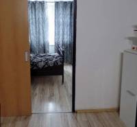 Innenraum mit Holzboden, Schiebetüren und schwarz-weißen Vorhängen in einer 3-Zimmer-Wohnung.