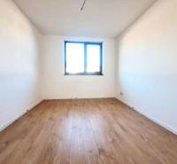 Blick in ein Zimmer mit weißen Wänden und einem Boden in Holzoptik in einem Einfamilienhaus.