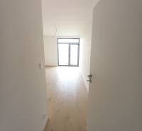 Innenraum eines Einfamilienhauses mit Holzdekorboden und großem Fenster.