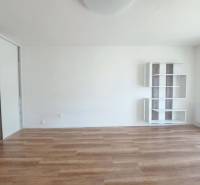 Ein Zimmer in einer 2-Zimmer-Wohnung mit einem Holzboden und weißen Wänden.