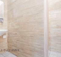 Büroinnenraum mit Waschbecken, Holzwänden und offener Tür.