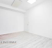 Innenraum mit weißen Wänden und Holzboden in einem Büro.