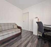 Ein Sofa und ein Schreibtisch in einem Einfamilienhaus mit Holzboden.